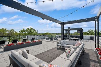 a rooftop patio with couches and chairs
